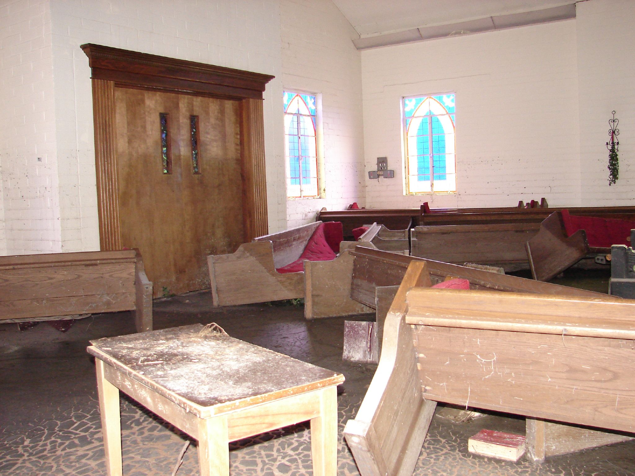 a church room has benches and tables inside