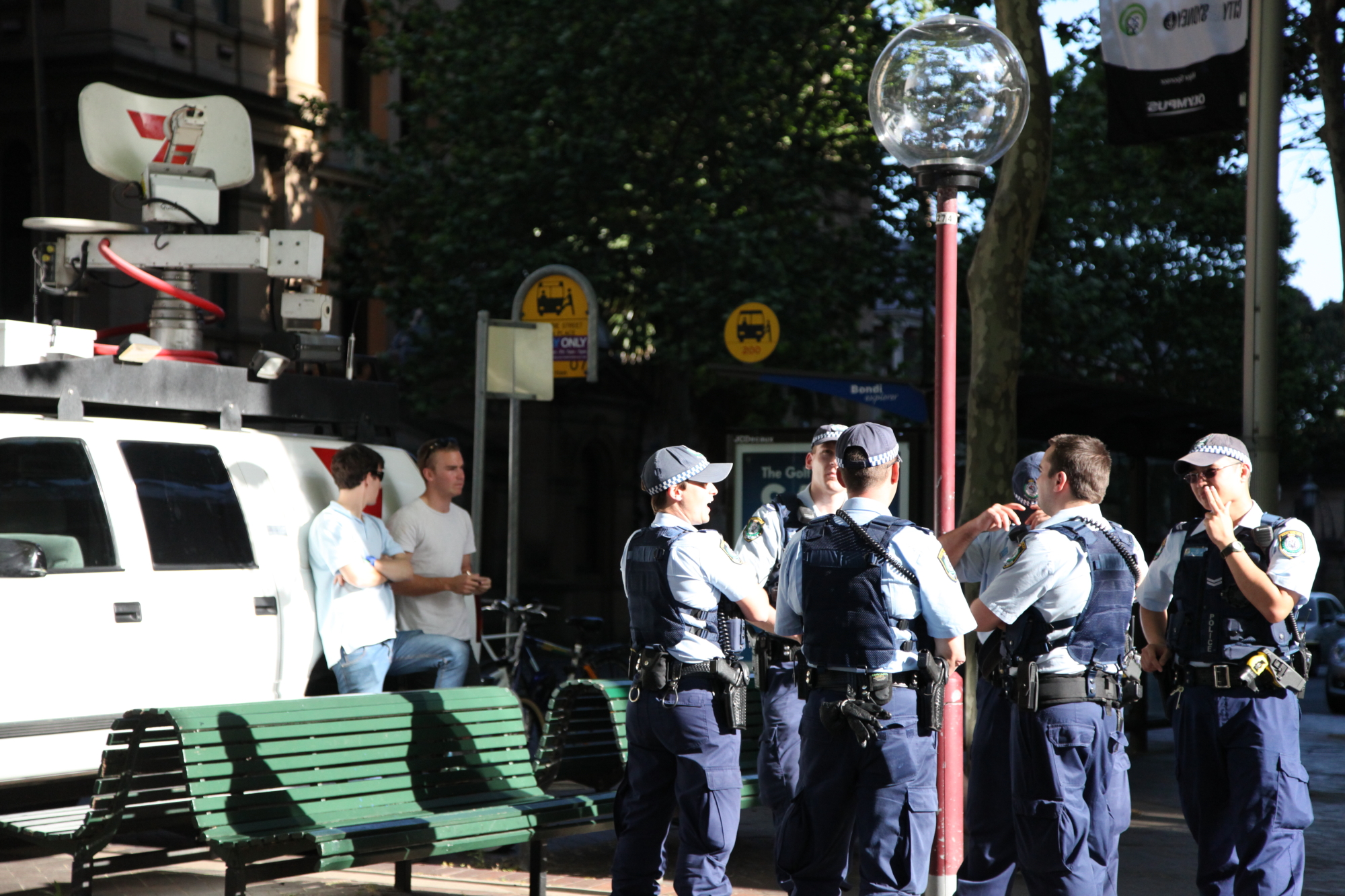 a group of men standing near a bench