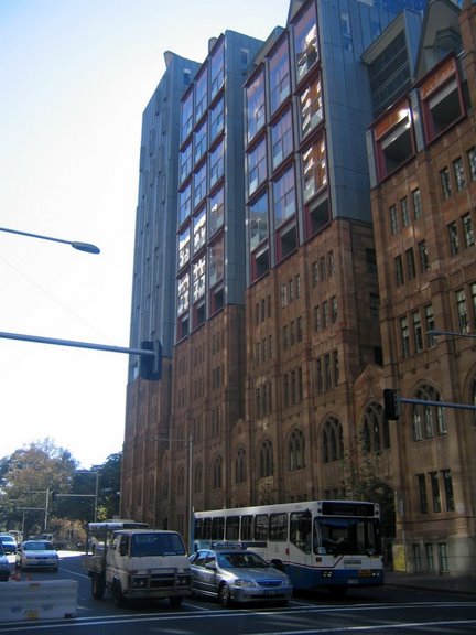 a view of an old building with large windows on the corner of the street