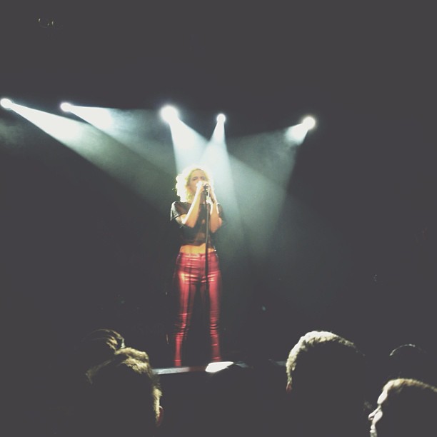 a woman in red pants is performing on stage