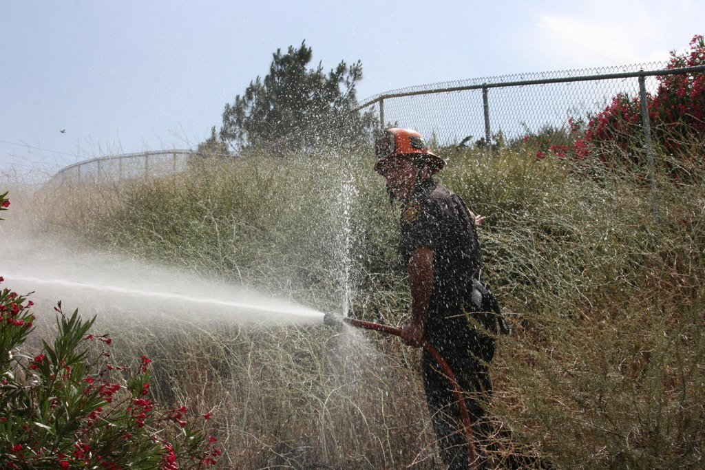 a man is spray spraying water on his fire hydrant