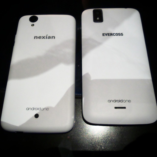 two white smartphones sitting side by side