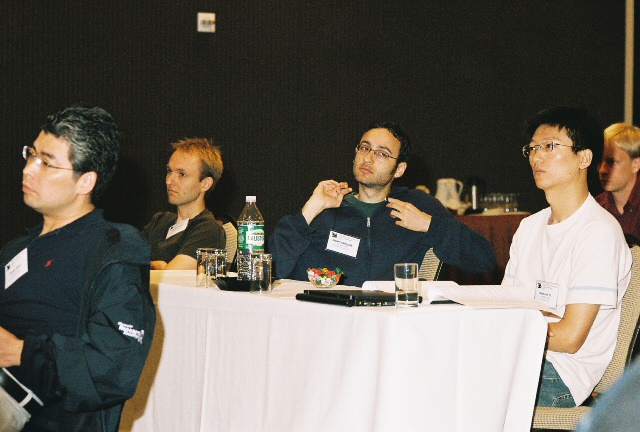 a group of men are sitting around a white table