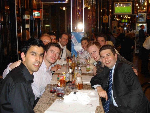 a group of people sitting at a long table