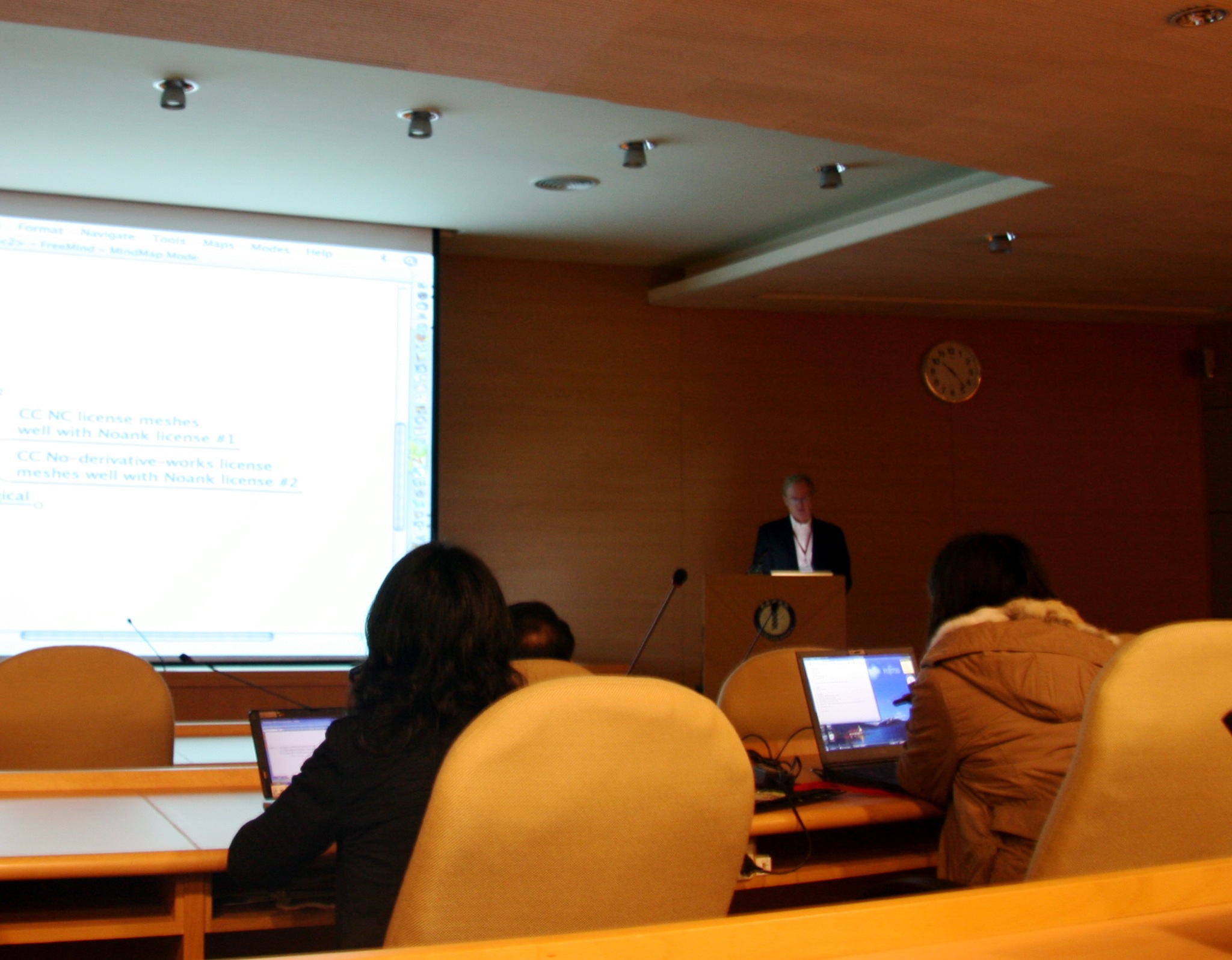 a group of people watching a presentation in a conference room