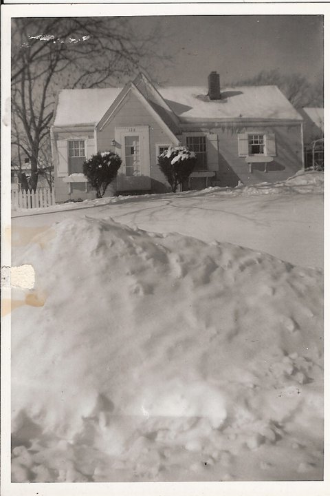 a large mound of snow sitting in front of a house