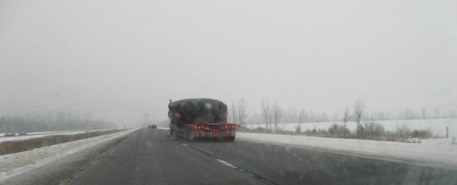 a truck carrying loads travels through heavy winter