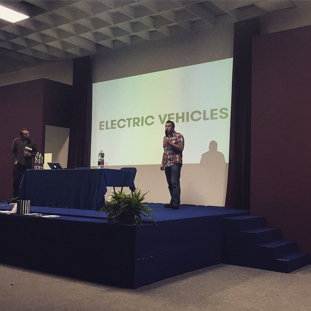 people at an electric vehicle exhibit on stage