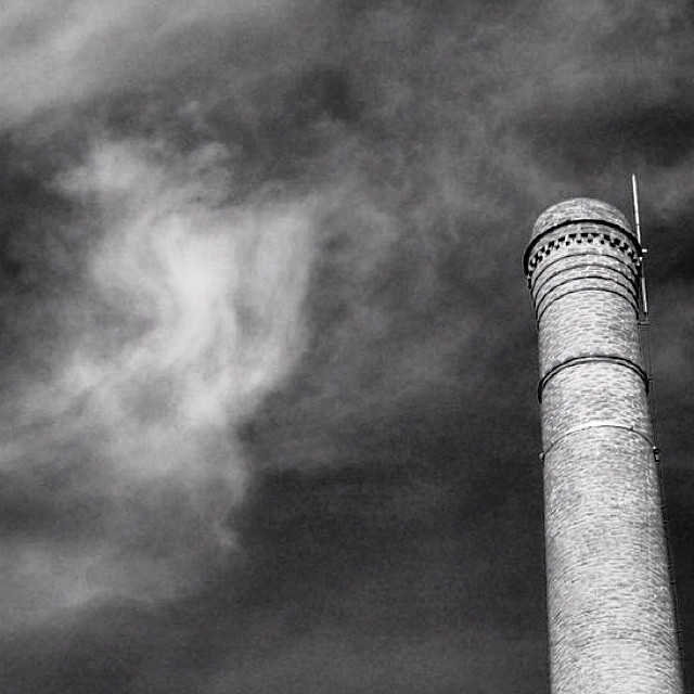 a tall tower is next to a cloudy sky
