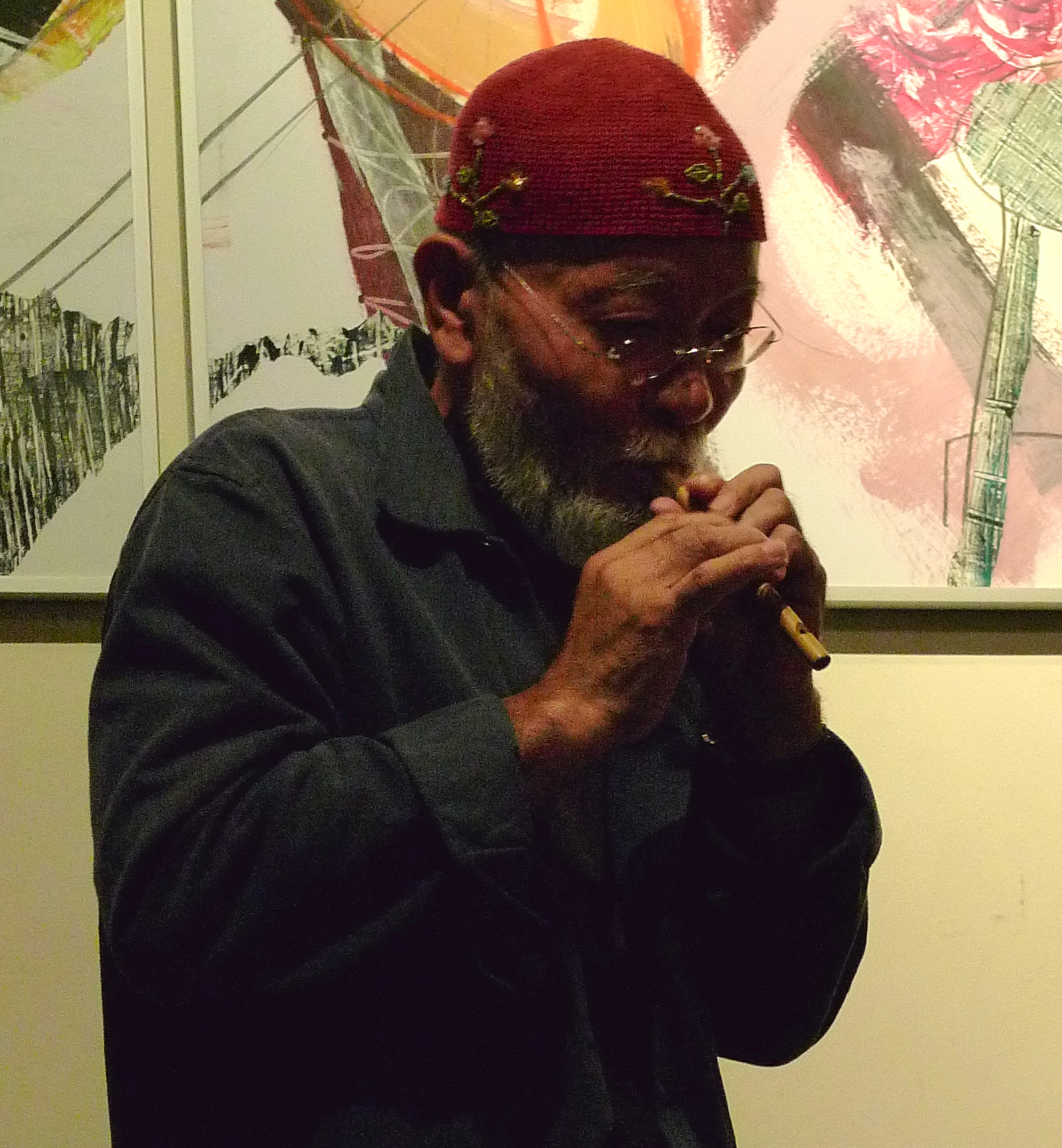a man in a red hat and glasses playing with a trumpet