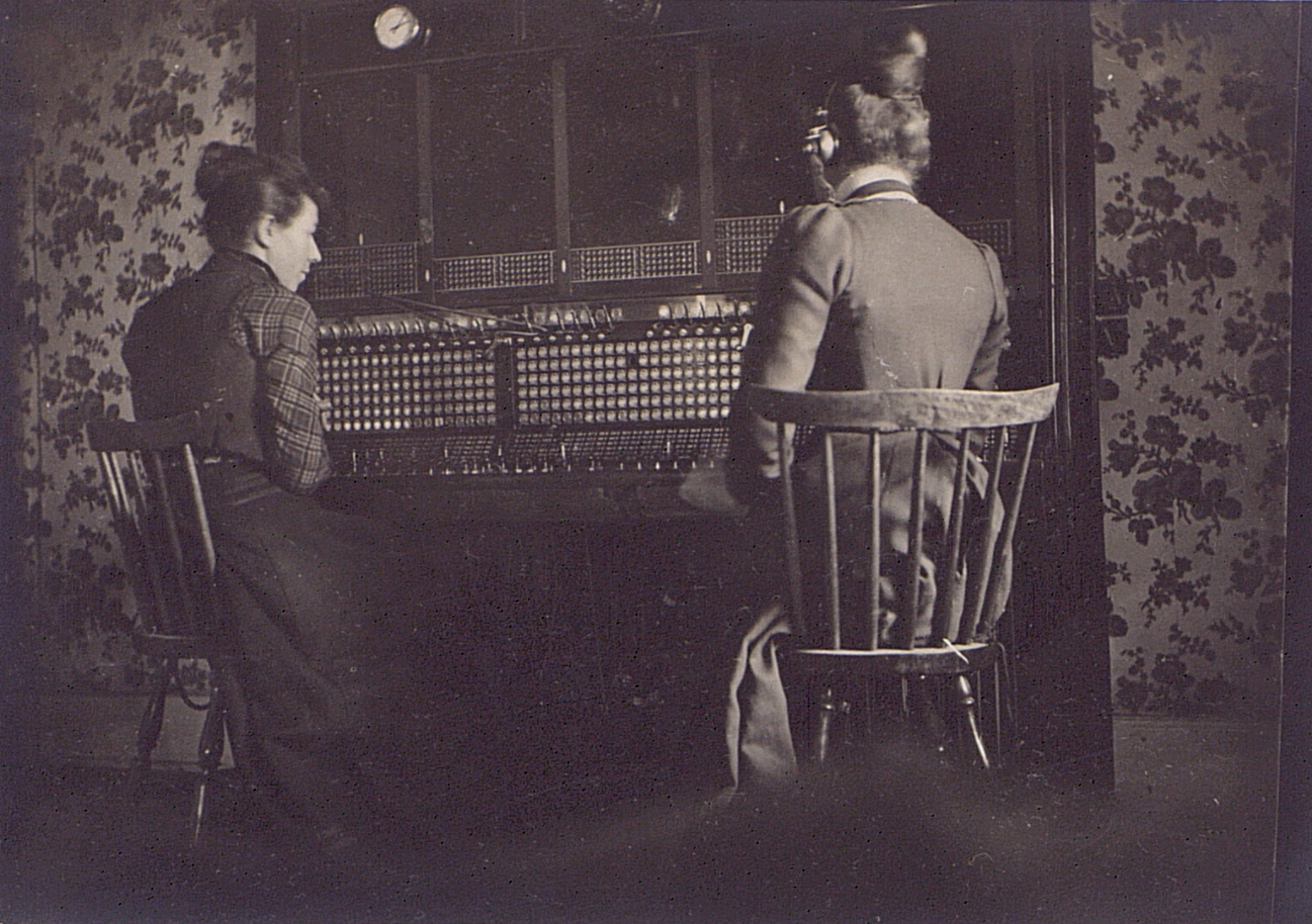 two men sitting at a table in front of a window