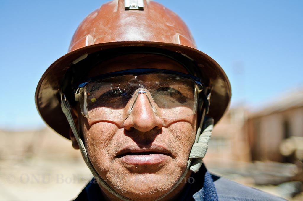 a man wearing glasses and a hardhat in the desert
