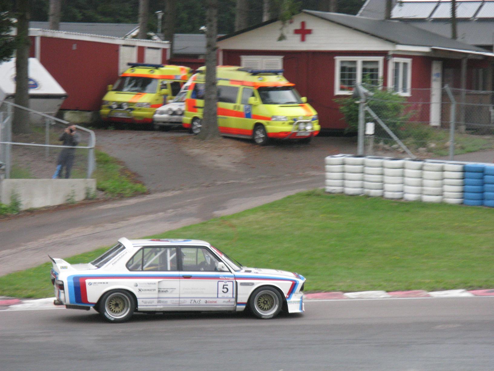 the car is driving down the road by emergency vehicles