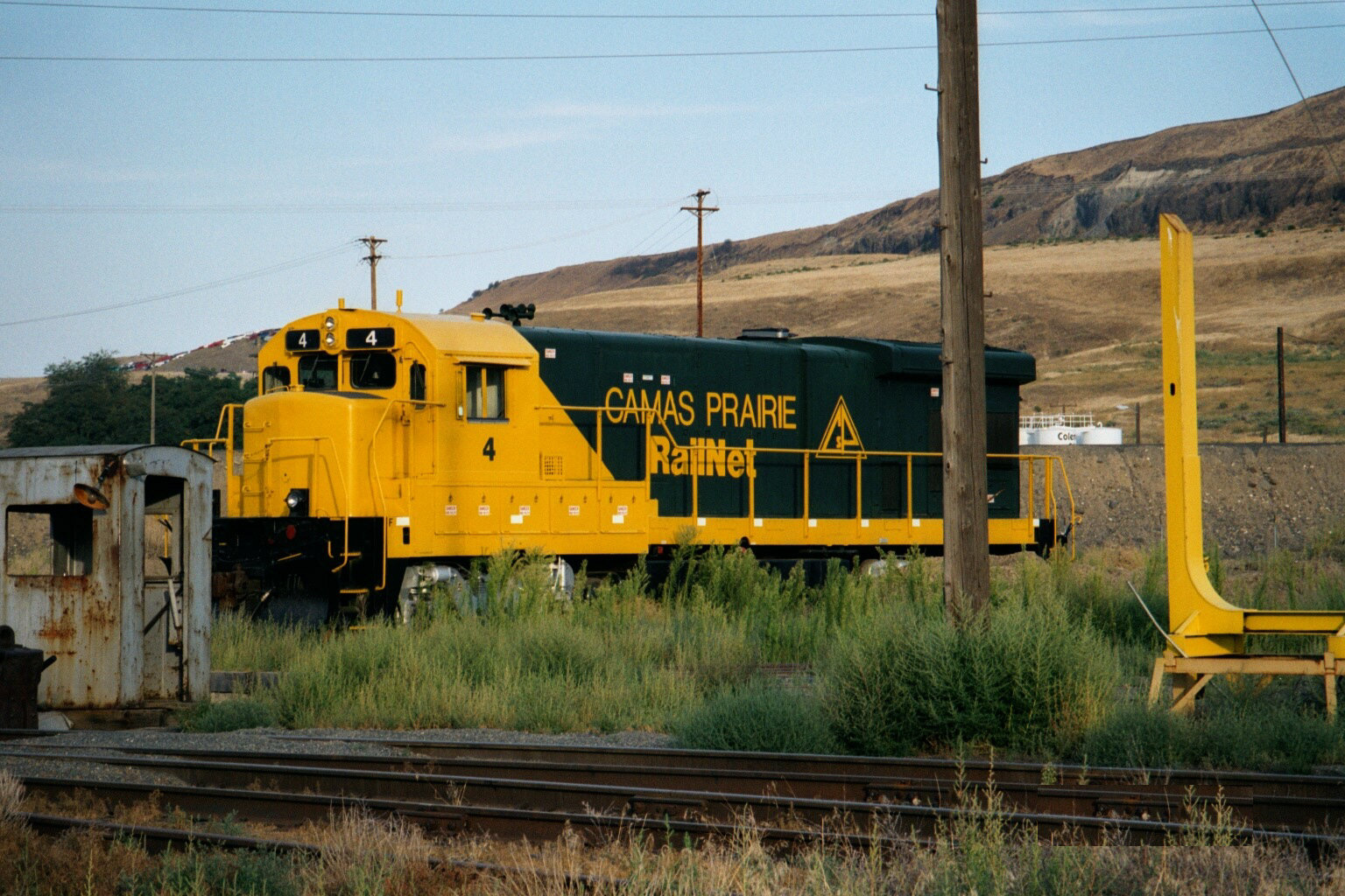 a yellow train traveling past a power line