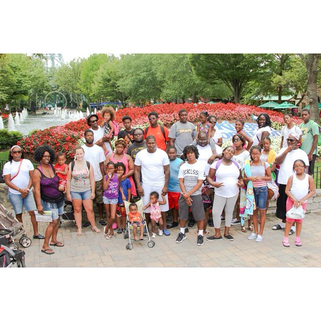 a group of people standing in a plaza next to a field