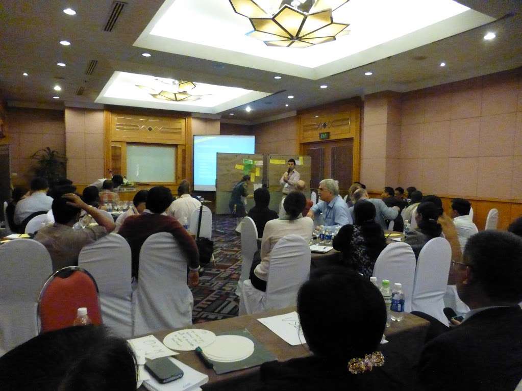 the large meeting is full of people sitting at their tables