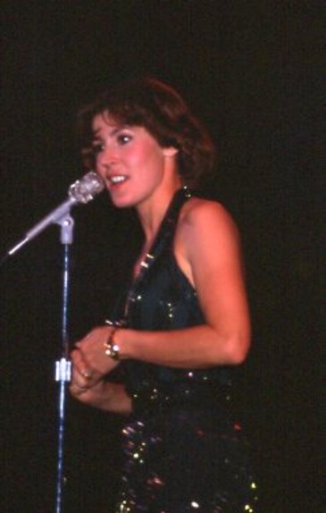 an image of a woman singing into a microphone