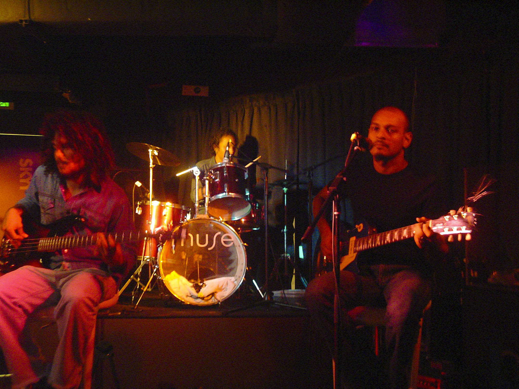 two people sit at a stage playing guitars