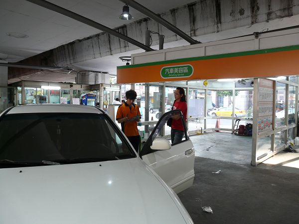 two women standing near a car in a gas station