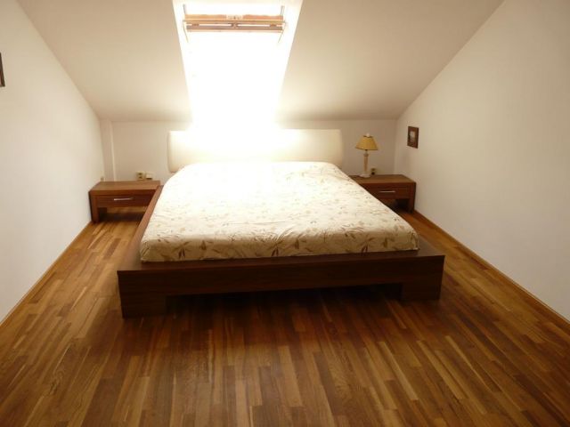 an open bedroom with hardwood floors and a window