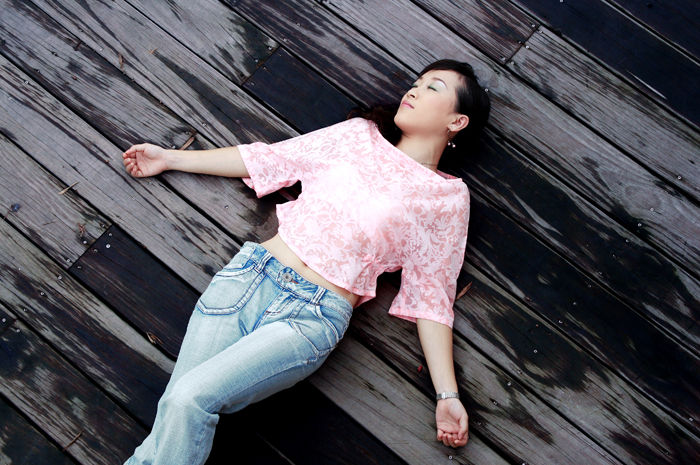 a girl laying on the wooden floor with her arm outstretched