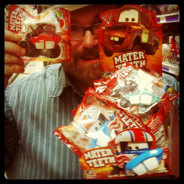 a person holding up three packs of assorted candies