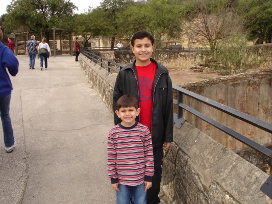 two children are standing on the edge of a wall