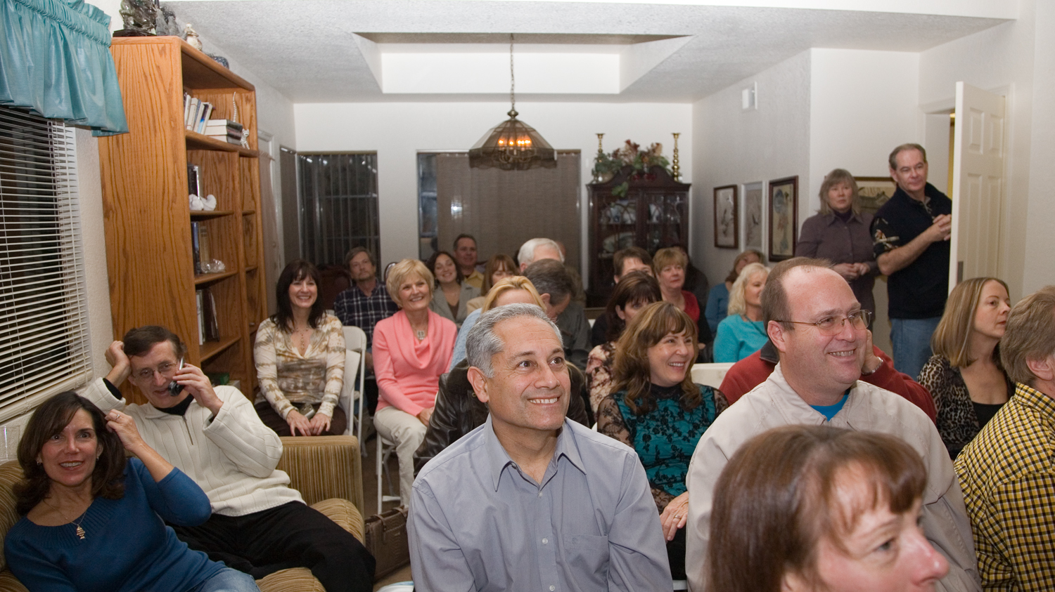 a group of people are sitting in a living room