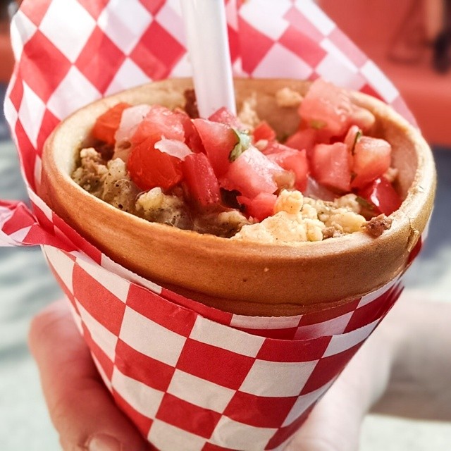 a red checkered paper cup with some fruit on top