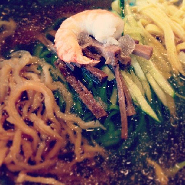 an asian style bowl of ramen with shrimp and vegetables