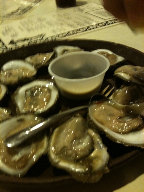 a plate of oysters with dipping sauce on a plate