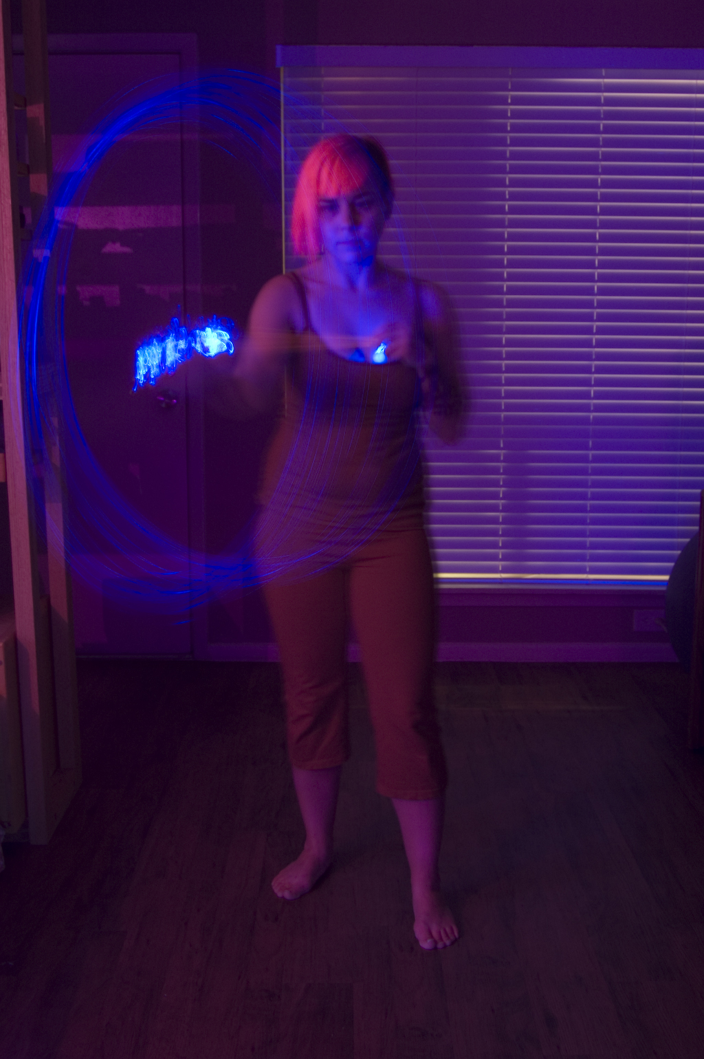 a woman is playing with a circular light in a room