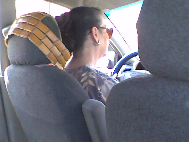a woman sitting in the back seat of a car wearing an arm guard