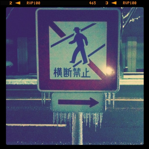 a traffic sign in chinese has icicles hanging from it