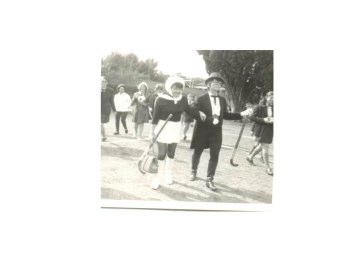 a group of people dressed in black and white walking down the street