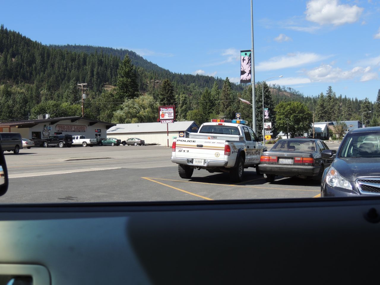 several cars sit parked on the side of the street