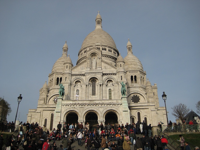 a large group of people are gathered outside of a large cathedral