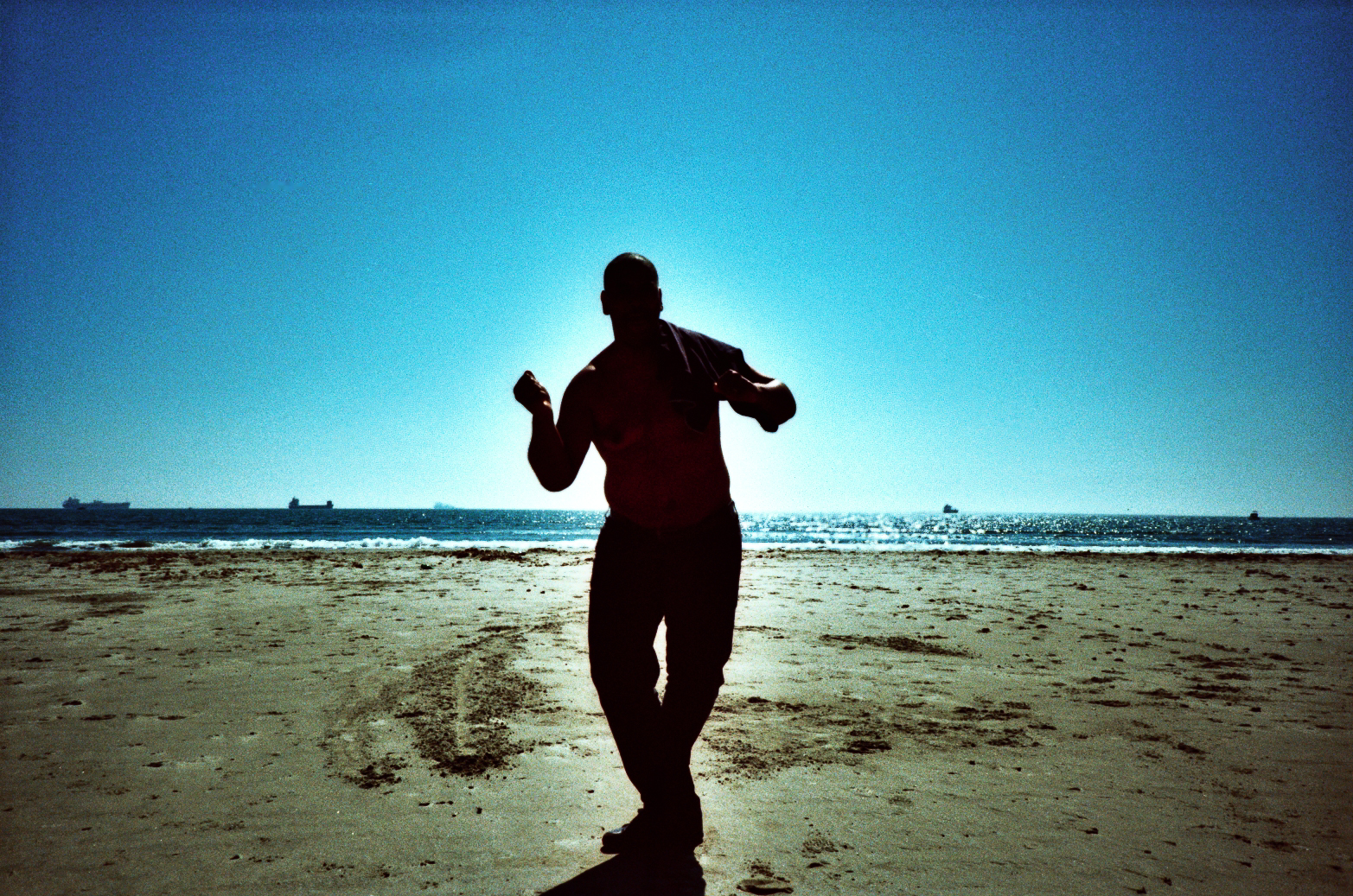 man walking on the beach at day with clear sky