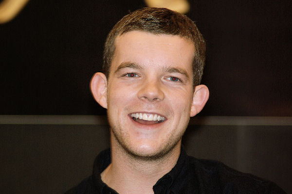 a man smiling with a black shirt on