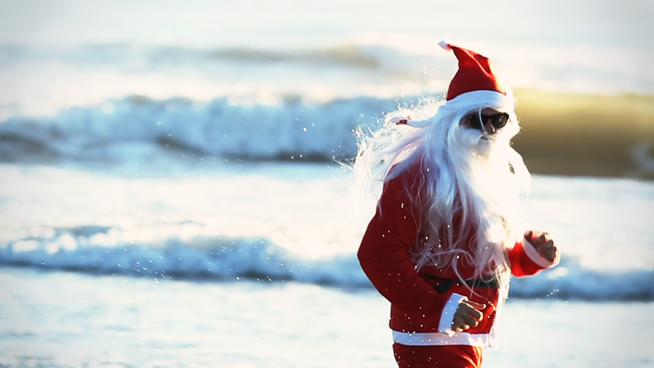 a santa clause on a beach near the water