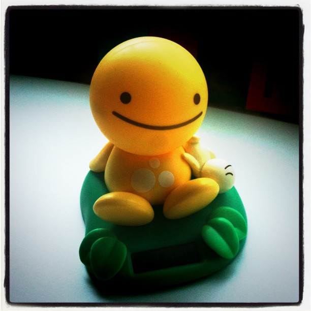 an image of a yellow figurine sitting on a bed