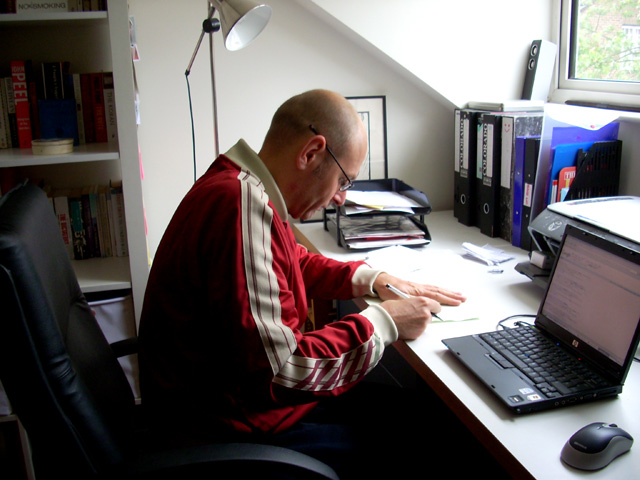 a man sitting at a desk in front of a laptop computer
