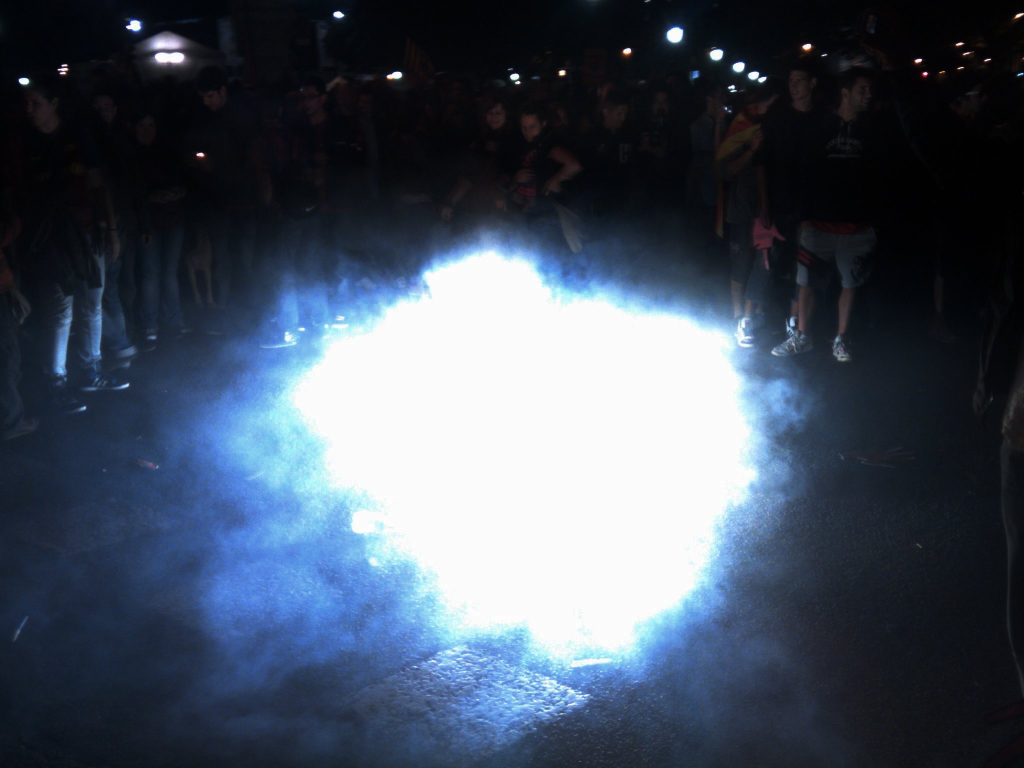 a small light shines in the dark near a group of people