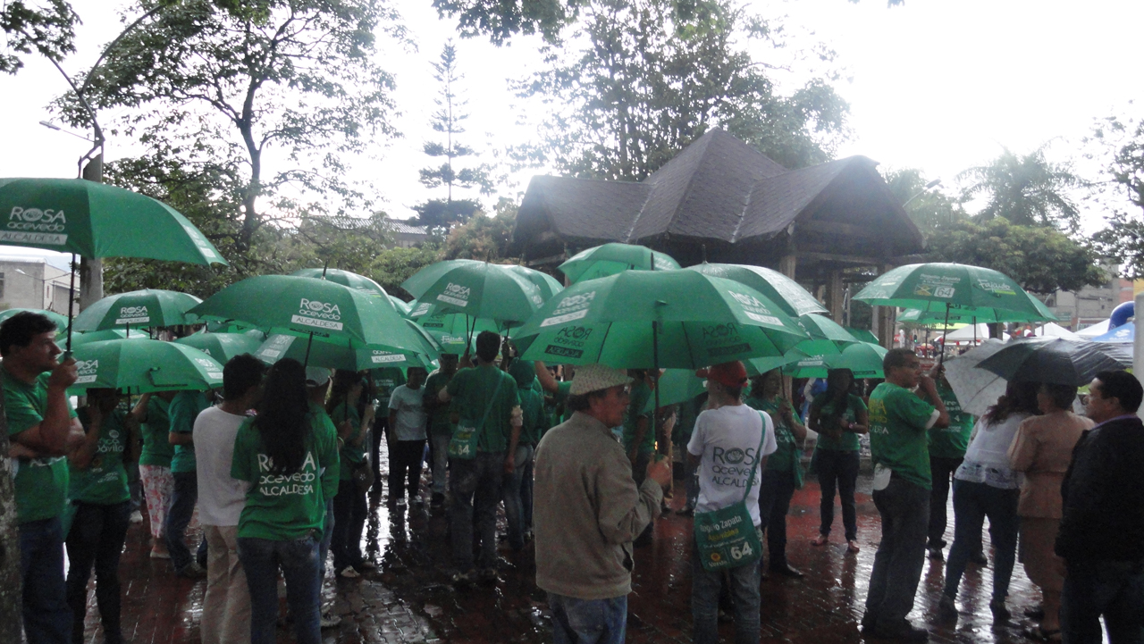 people are holding green umbrellas in the rain