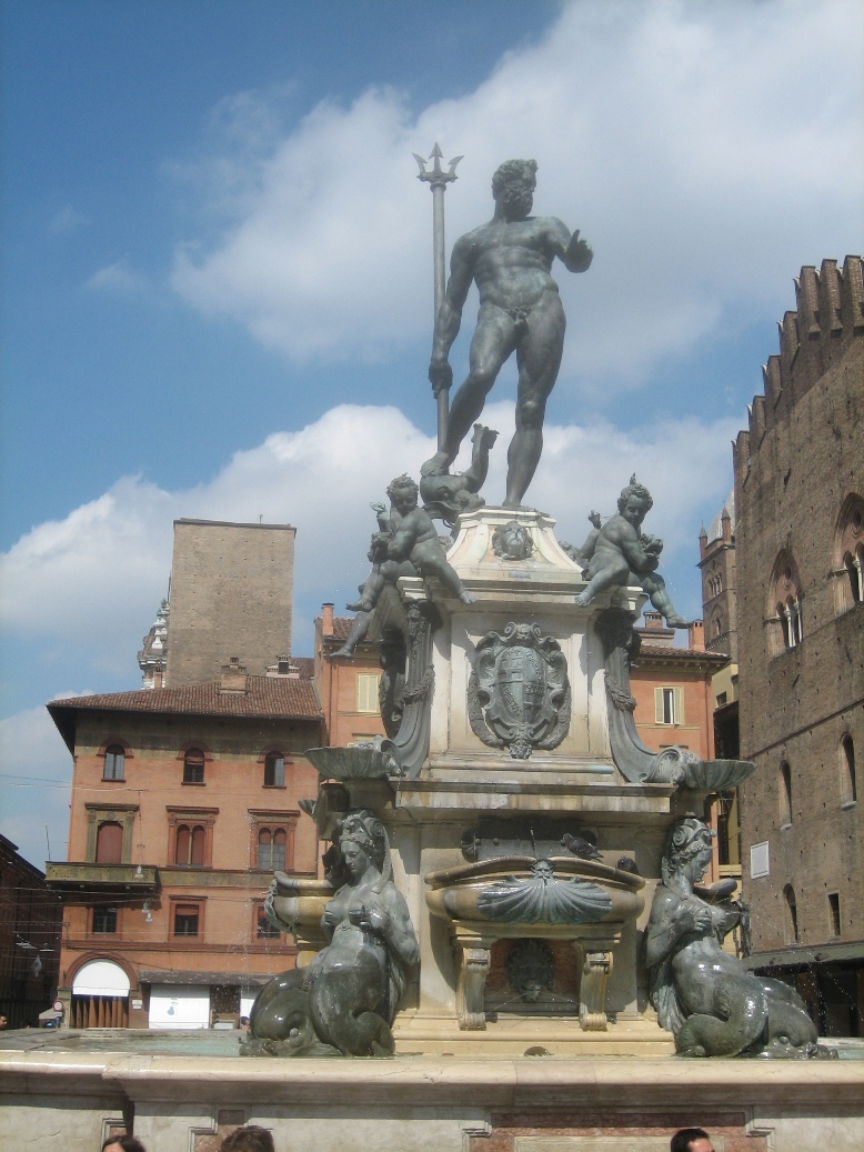 a statue with a sword on top in front of some buildings