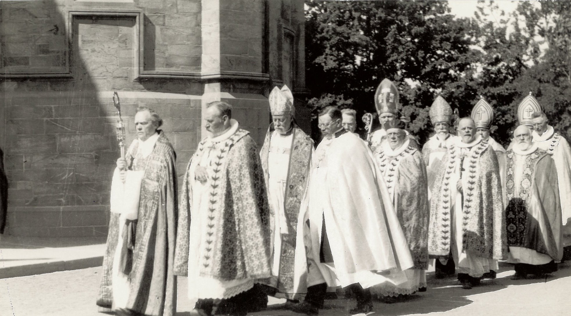 there are nine priests in uniform standing together