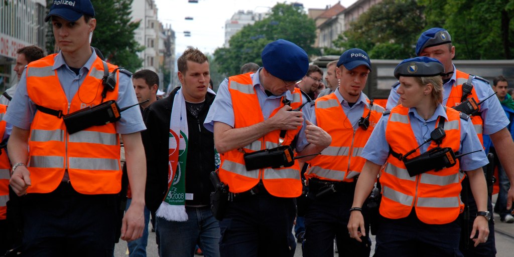 several people walking with safety vests on and wearing hats