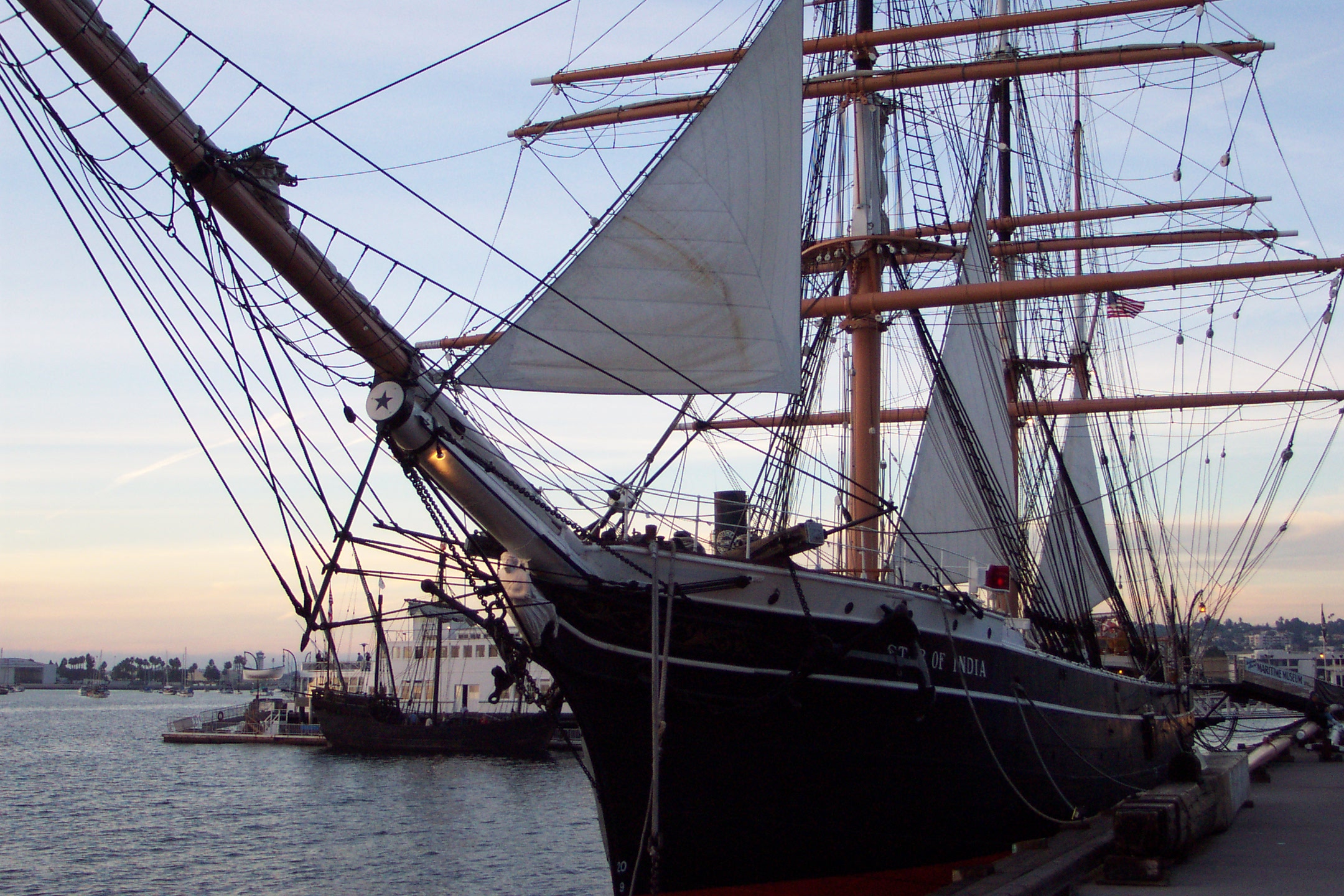 a boat docked at the dock with another ship nearby