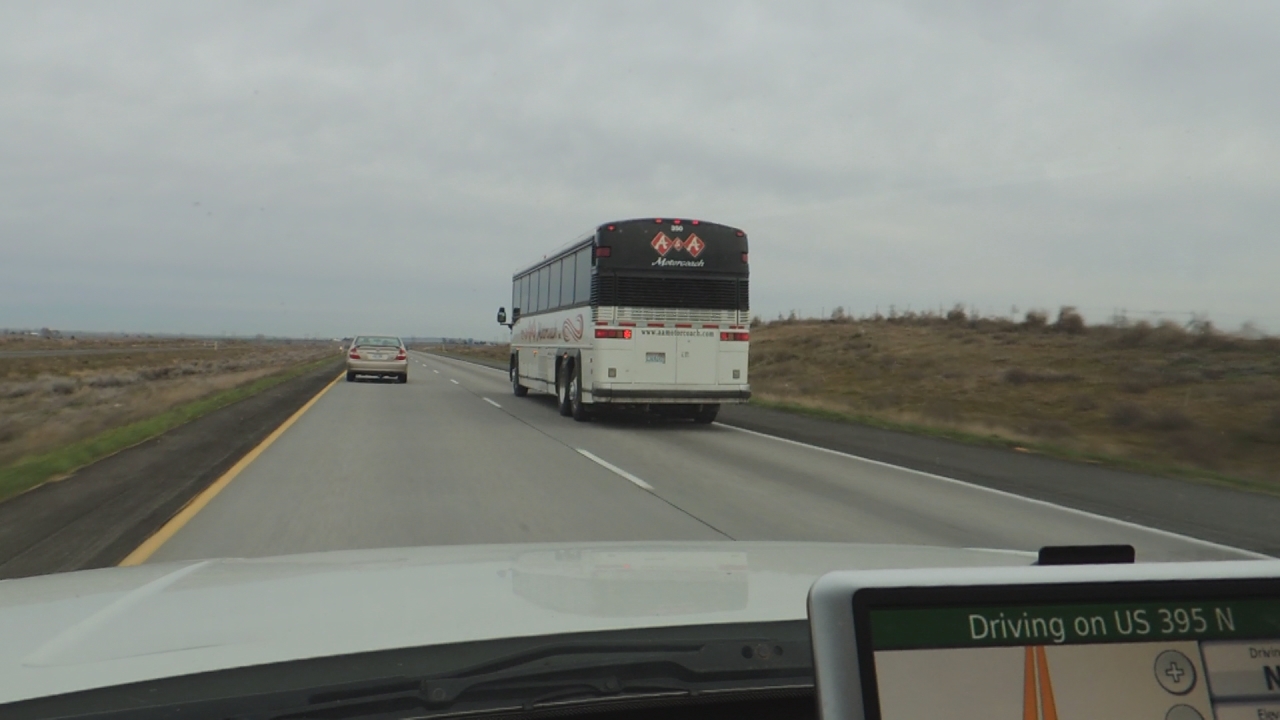 a bus driving down a highway on a cloudy day