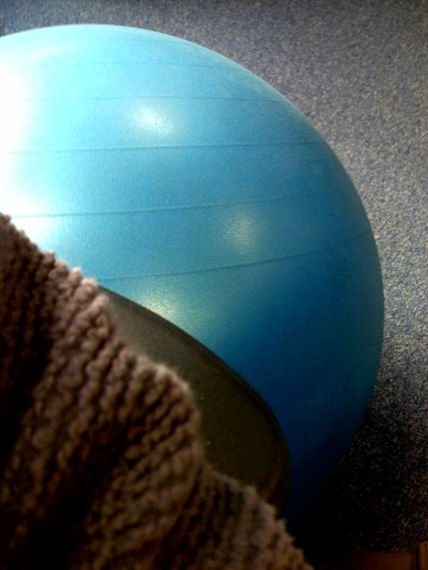 a pair of socks and a blue ball on an exercise floor